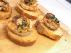 Xếp các lát bánh mì nướng ra đĩa, đặt tôm lên trên, xếp các lát tỏi lên những con tôm là có thể dùng ngay rồi nhé!