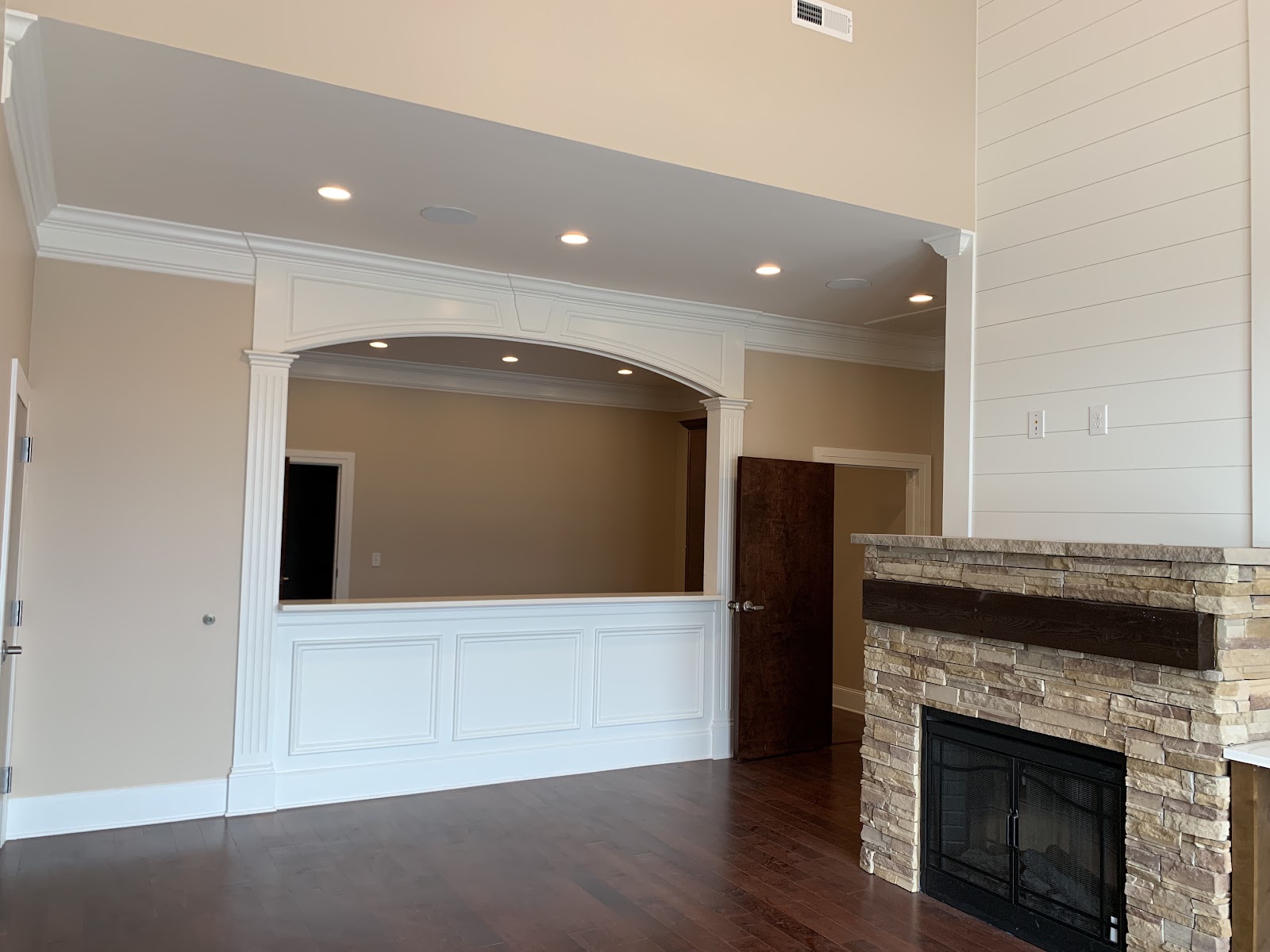 Interior of a health clinic showing a stone fireplace with a dark wood mantel and a white paneled counter under an arched opening.