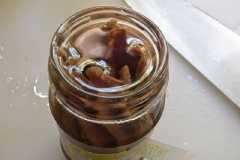 Gấp cá anchovy mặn ra khỏi hũ cho vào chén sạch, phần dầu olive bên trong hũ giữ lại.