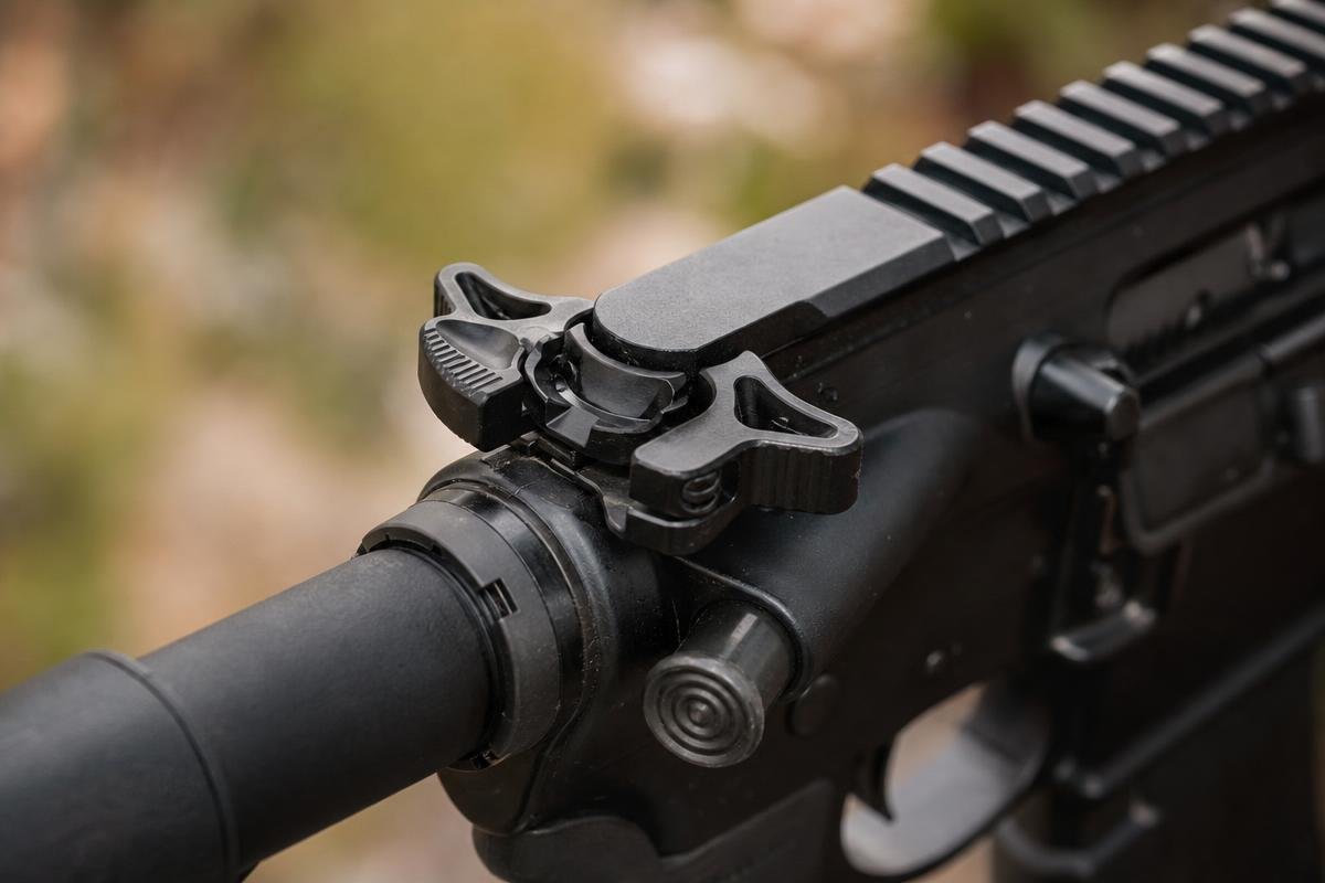 Close-up of an ambidextrous charging handle latch and gas-deflecting body detail