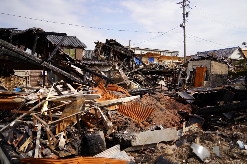 地震と火災で倒壊した木造家屋の瓦礫のイメージ