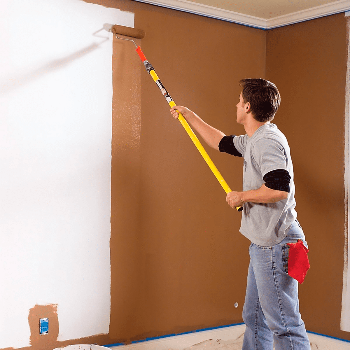 Pintor profesional aplicando pintura interior con pértiga en vivienda de Tenerife