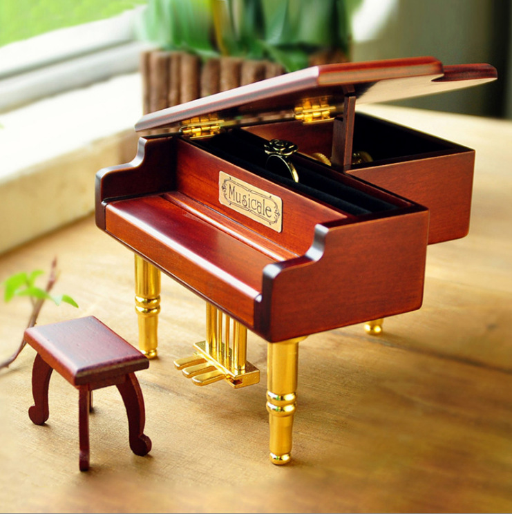 Wooden music box in the shape of a piano with metal feet