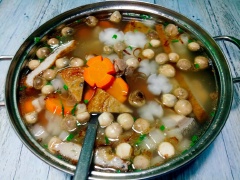Kế tiếp, cho chả cá và nấm rơm vào nấu trên lửa vừa.