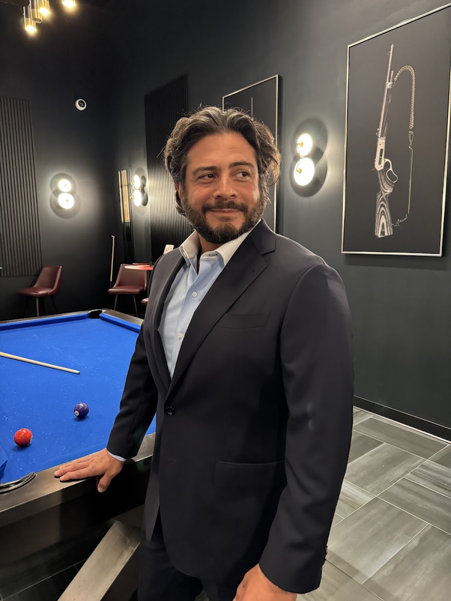 Blue windowpane check bespoke suit worn open-collar in the Bespoke By CB Miami showroom — smart casual tailoring