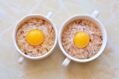 Chia hỗn hợp thịt làm 2, cho vào 2 tô sứ, ấn hơi sâu 1 chút ở trung tâm. Đập trứng gà cho vào mỗi tô sao cho lòng đỏ trứng nằm ở giữa.