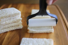 Cắt viền của bánh mì đi, chỉ giữ lại phần ruột trắng mềm. Dùng vật nặng cán dẹt bánh mì.