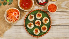 Xếp bánh ra đĩa, cho mỡ hành, tôm cháy, tỏi phi lên trên bánh, ăn kèm bánh với nước mắm chua ngọt và đồ chua. Bánh ít trần có vỏ bánh dẻo dẻo dai bọc bên trong phần tôm thịt đậm đà, bùi béo của đậu xanh, chấm kèm với nước mắm chua chua, ngọt ngọt, tất cả hòa quyện với nhau tạo nên sự độc đáo, lạ miệng và vô cùng hấp dẫn.