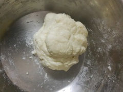 Cho tiếp bột mì, bột khoai tây, bột nở và đường vào và nhào đến khi đều, lúc này khối bột sẽ mềm mịn và không dính tay. Giấy nến cắt thành các miếng nhỏ, vo bột thành các viên tròn nhỏ đặt lên giấy nến, dùng tay ép nhẹ để các viên bột dính lại với nhau.