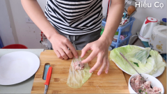 Làm bắp cải cuộn thịt. Mọi người xem video sẽ thấy cách mình cắt lá bắp cải ra rất to, đẹp và dễ cắt. Thịt băm mọi người ướp gia vị. Trụng lá bắp cải và hành lá. Sau đó múc ít thịt cho lên bắp cải rồi gói kín lại, buộc hành lá để cố định.