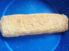 Đun nóng chảo chống dính, dùng khăn giấy thoa đều dầu ăn lên mặt bếp rồi đổ 1 lớp trứng mỏng tráng đều. Chờ lớp trứng hơi khô mặt thì xếp lá cải bó xôi ở gần viền ngoài. Tiếp đó cuộn tròn 1/2 miếng trứng, kéo trứng về 1 bên chảo, tiếp tục đổ 1 ít trứng vào chảo. Lại xếp lá cải bó xôi và cứ thế chờ trứng khô mặt là gấp trứng. Tiếp tục gấp rồi đổ trứng cho đến hết phần trứng gà.