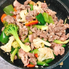 Cho cà rốt, bông cải xanh-trắng, ớt chuông vào chảo, đậy nắp 3 phút. Cho thịt bò vào chảo trộn đều.