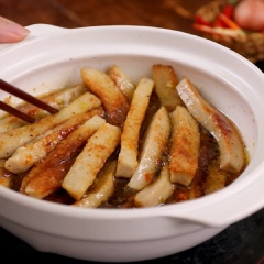 Bật bếp ở lửa nhỏ, nấu cho nước mắm sôi lên và hơi sệt lại thì cho chả lụa vào nồi, đảo đều và kho cho nước mắm sánh lại, kẹo sệt. Cuối cùng cho 15gr hành lá cắt khúc vào, đảo nhanh qua rồi tắt bếp.