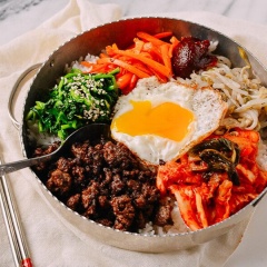 Xới và bới cơm, xếp tất cả các nguyên liệu lên trên mặt cơm, đừng quên rưới đều dầu mè và thêm sốt ớt bột Hàn Quốc. Đập vỡ lòng đỏ trứng, trộn đều cơm và thưởng thức thôi nào!!!