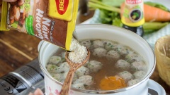 Bắc nồi nước hầm xương lên bếp, thêm cà rốt vào rồi nấu lên. Nước sôi bạn thả thịt viên vào nấu chín, hớt bỏ bọt bẩn để nước canh được trong hơn. Khi nước sôi lại thì bạn nêm vào canh 1/2 muỗng canh hạt nêm để món canh có vị vừa ăn. Sau đó bạn cho lần lượt cải bẹ xanh, nấm rơm và gừng vào nồi. Nấu đến khi nước sôi lại lần nữa thì tắt bếp.