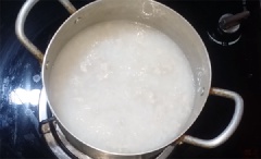 Cho gạo vào nồi, rang đều cho hạt gạo vàng thơm thì đổ ngập nước, đun sôi rồi hạ lửa nhỏ vừa. Thỉnh thoảng khuấy đều cho đến khi cháo chín nhừ (khoảng 30 phút). Cho cồi sò điệp vào và nấu cho đến khi cháo đặc quánh như ý muốn. Cuối cùng, thêm tôm và ít gừng còn lại, khuấy đều tay. Tắt bếp, nêm nếm muối cho vừa ăn. Thêm một ít dầu mè, hành lá là món ăn của chúng ta hoàn thiện rồi.