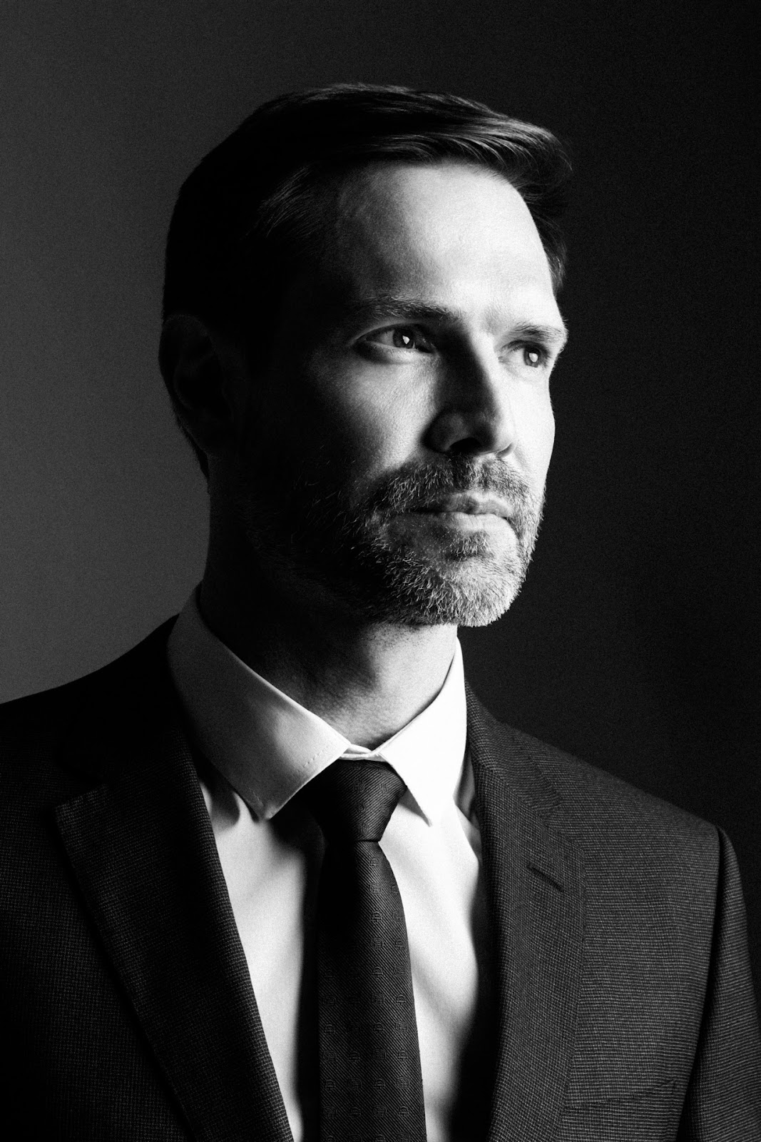 Retrato masculino em preto e branco com luz lateral, terno e gravata.