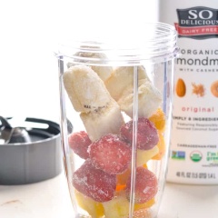 Khi cần xay sinh tố, bạn lấy dâu, xoài, chuối trong tủ đông ra, cho vào máy xay sinh tố, rót sữa hạnh nhân, rắc muối vào. Bật công tắc xay nhuyễn hỗn hợp.