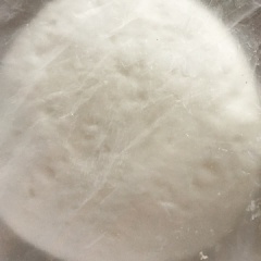 Đun 200ml nước sôi, cho vào hỗn hợp bột và trộn đều từ dưới lên. Lấy bột ra để trên khay đã được tráng ít dầu ăn, tiến hành nhào bột đều tay. Sau đó dùng bịch nilon hoặc màng bọc thực phẩm gói lại, ủ trong vòng 8 - 10 phút.