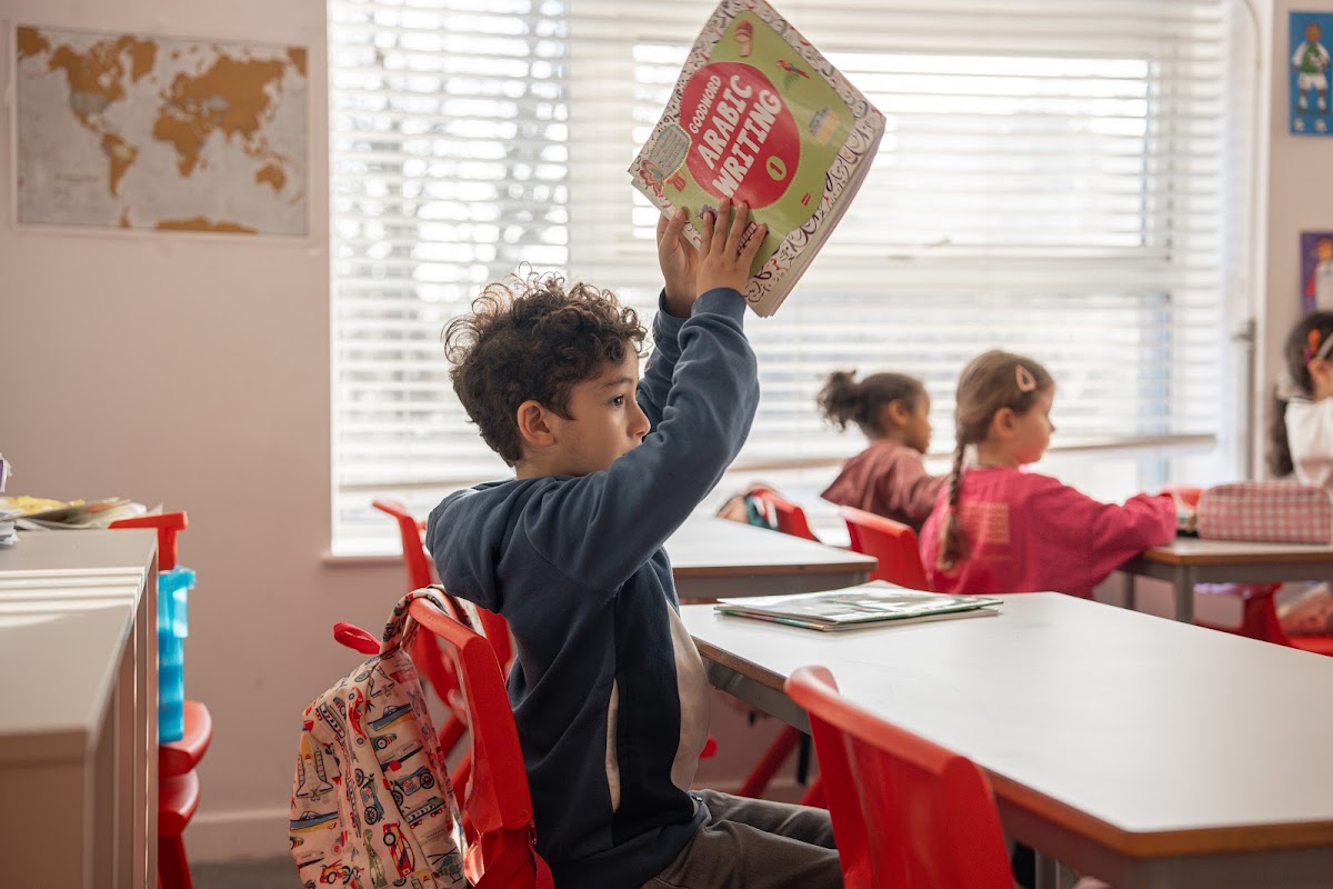Student holding up his Arabic Writing book