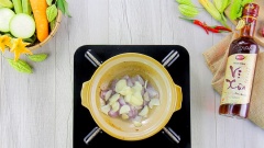 Bắc lên bếp một chiếc nồi đất, cho thịt ba chỉ vào rang đến khi phần mỡ tan chảy chỉ còn lại những miếng tóp mỡ vàng giòn. Vớt tóp mỡ ra để riêng, giữ lại mỡ trong nồi. Cho tiếp 30gr hành tím và 30gr tỏi thái lát mỏng vào nồi, phi cho hành tím và tỏi vàng giòn, thơm lừng.