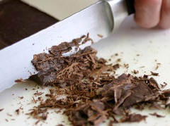 Băm thật nhỏ thanh chocolate ra rồi cho vào tô, đổ sữa tươi không đường, đường vào rồi khuấy thật đều.
