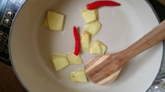 Trong một chảo, cho 2 muỗng canh dầu ăn vào, đun nóng. Thêm gừng tươi thái lát và ớt vào xào trong 1 phút. Say đó thêm nước ướp gia vị ướp gà lúc trước vào, rồi thêm nước dừa. Đun sôi hỗn hợp nước rồi cho gà vào trong chảo, đun nhỏ lửa trong khoảng 45 phút. Sau 45-60 phút, nước dừa sẽ giảm một nửa. Lúc này thịt gà sẽ có màu nâu và thịt rất mềm.
