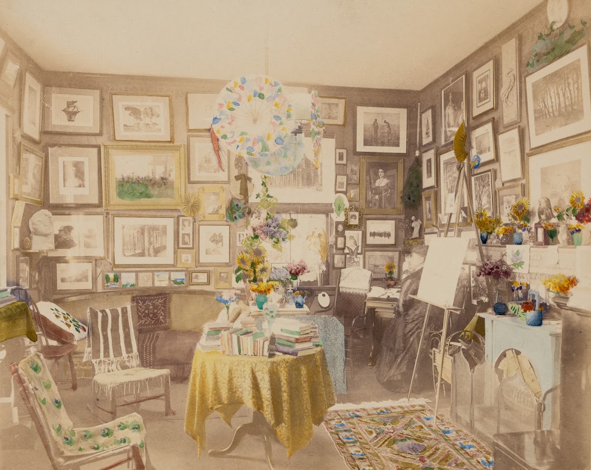 Interior view of room with books prints and easel