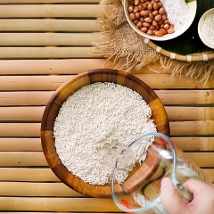 Đem 200 gram lạc rửa sạch, vớt ra. Sau đó, bắc nồi nước sôi, cho nửa muỗng cà phê muối vào nồi, cho tiếp đậu phộng vào luộc khoảng 40 phút, vớt ra để ráo nước. Ngâm 500 gram gạo nếp khoảng 2 - 3 tiếng, rồi vo sạch, vớt ra để ráo nước.