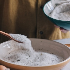Trộn đều hỗn hợp muối đường, rải 1 lớp dày xuống dưới khay. Dùng 1 quả trứng ấn xuống lớp muối đường để tạo thành những lỗ tròn.