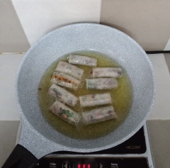 Chiên chả giò vàng đều. Gắp ra dĩa có lót giấy thấm dầu. Xếp xà lách và cắt khoanh cà chua cho ra dĩa. Pha nước mắm chua ngọt.