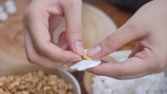 Cho một miếng bột nhỏ ra tay, ấn dẹp miếng bột ra cho một viên đậu phộng và cùi dừa vào, gói lại và lăn tròn thành viên nhỏ. Làm tương tự như vậy cho đến hết nhân. Hoặc là bạn có thể bọc riêng từng nhân cùi dừa và đậu phộng.