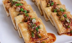 Cho đậu hũ chiên sốt tương ra đĩa, rưới lên nước sốt là có thể thưởng thức.