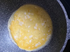 Láng đều 1 muỗng canh dầu ăn trong chảo. Đánh tan 1 quả trứng vịt rồi cho vào dàn đều, chiên chín. Sau đó cho cơm chiên vào nằm gọn ở 1 bên miếng trứng, gặp nửa cọn lại phủ kín lên trên cơm chiên.