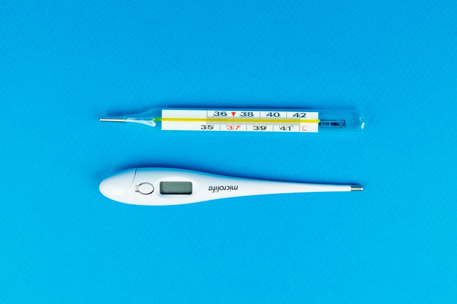 진단 차트와 체온계, 펜이 놓인 책상, 야외활동 후 주의해야 할 고열 및 증상 확인의 중요성