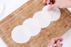 Xếp 4 miếng vỏ há cảo ra mặt phẳng như hình. Phủ ít bột bắp cho chống dính. Múc 1 ít hỗn hợp vừa trộn cho vào giữa. Gấp vỏ bánh theo chiều ngang, cuộn từ phải sang trái và tạo thành hình hoa hồng. Hòa tan 1 muỗng canh bột bắp với 20ml nước. Phết lên viền vỏ há cảo, kéo xuống tạo hình cánh hoa.