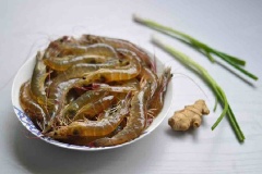 Tôm chọn những con có kích thước nhỏ để có thể ăn luôn cả vỏ. Đem cắt sơ đầu tôm, rửa sạch, để ráo, ướp chút rượu vang và tiêu xay. Hành lá cắt khúc; gừng thái lát rồi thái tiếp thành sợi.