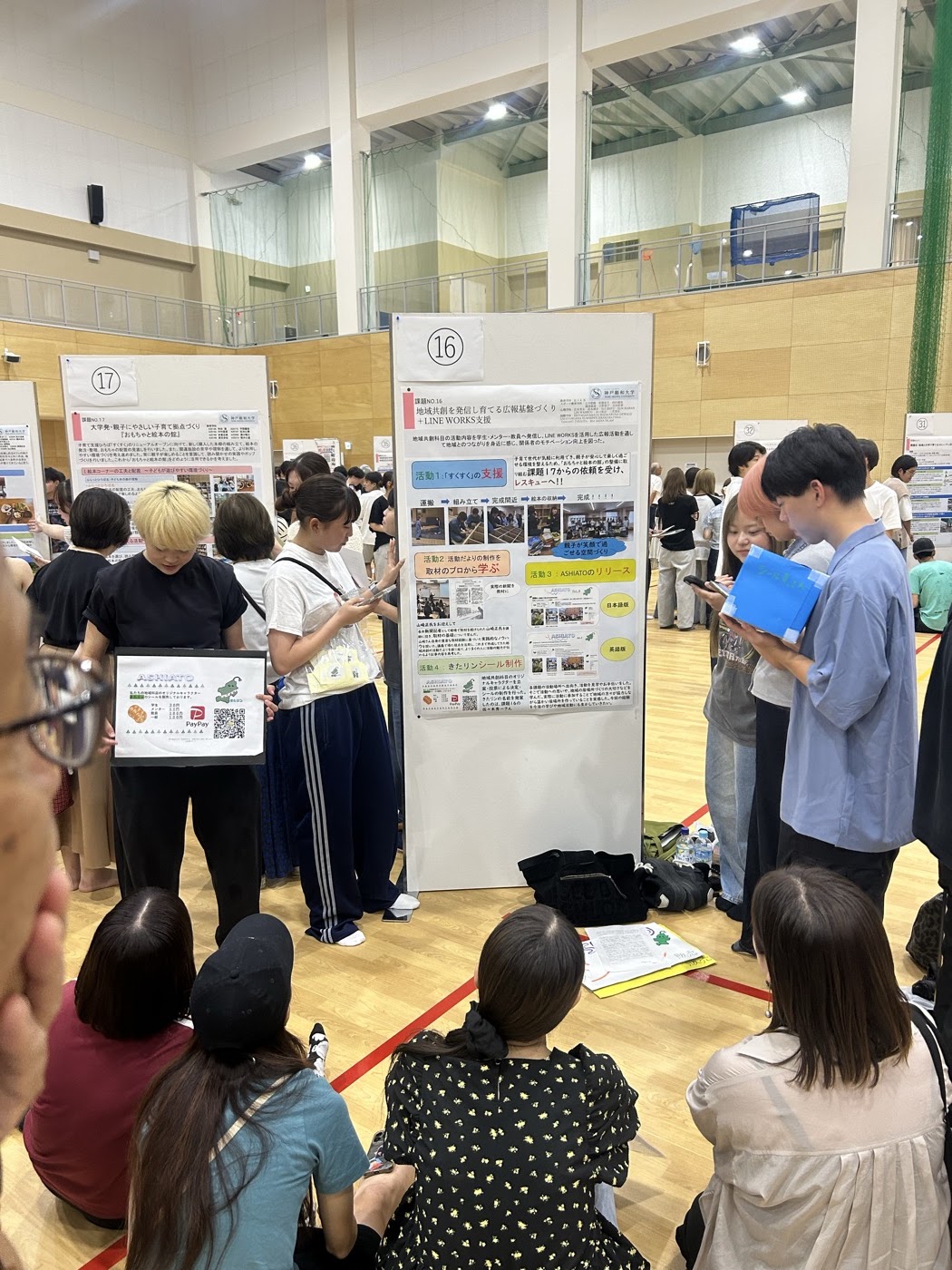 広報基盤づくりのポスターを囲んで話を聞く来場者