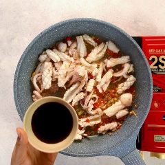 Nêm vào mực 1 muỗng canh nước mắm, 1 muỗng canh dầu hào, 1 muỗng canh sa tế, 1 muỗng canh đường, đảo nhanh tay và đều.