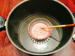 Làm phần chocolate màu hồng (phần nhân), bạn cắt cam rồi vắt và lọc lấy 40ml nước cốt cho ra bát. Đặt bát nước cốt cam vào nồi đun cách thủy cho nước cốt cam nóng lên, tiếp theo cho mật ong, chocolate màu hồng hoặc trắng vào cùng với nước cam, khuấy đều cho tới khi chocolate tan chảy hết thì cho bơ, kem whipping vào cùng. Khuấy đều cho nguyên liệu hòa quyện là tắt bếp, lấy ra để cho nguội hẳn.