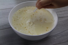 Sau đó đánh 2 lòng đỏ cùng 3 quả trứng gà cho tan hết. Cho từ từ từng muỗng sữa ấm vào hỗn hợp trứng gà, vừa cho vừa khuấy đều. Cho thêm vanilla và một xíu muối vào hỗn hợp này để tạo mùi.