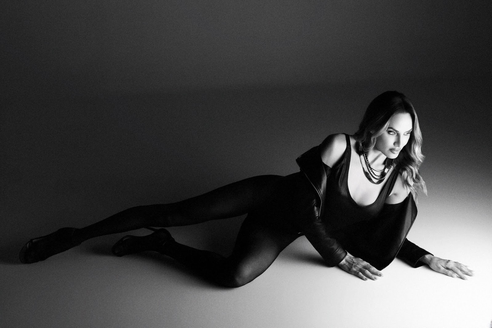 Veronica Zardo fotografada de corpo inteiro em pose horizontal no estúdio, em preto e branco