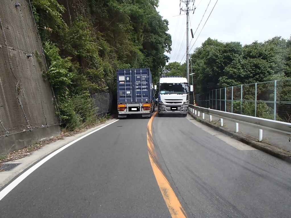 国道428号の狭隘区間で大型車がすれ違う様子