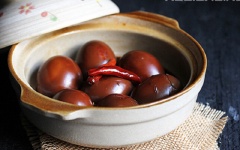 Tiếp theo, cho trứng gà, nước tương, rượu trắng, nước dừa, đường trắng, nước mắm, ớt để nguyên trái vào 1 cái nồi đất, nấu khoảng 10 phút.