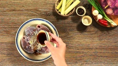 Nêm gia vị vào cá gồm 1 muỗng canh hành tím, 1 muỗng canh tỏi, 1 muỗng canh hạt nêm, 1/2 muỗng cà phê tiêu và 3 muỗng canh nước mắm. Trộn đều và để cá thấm gia vị trong khoảng 30 phút.