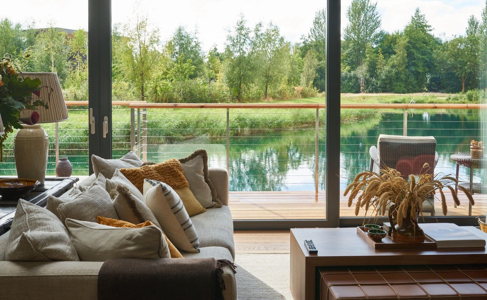A Cotswold-stone living room with full-height stone fireplace and double-aspect windows, looking onto the southern hills