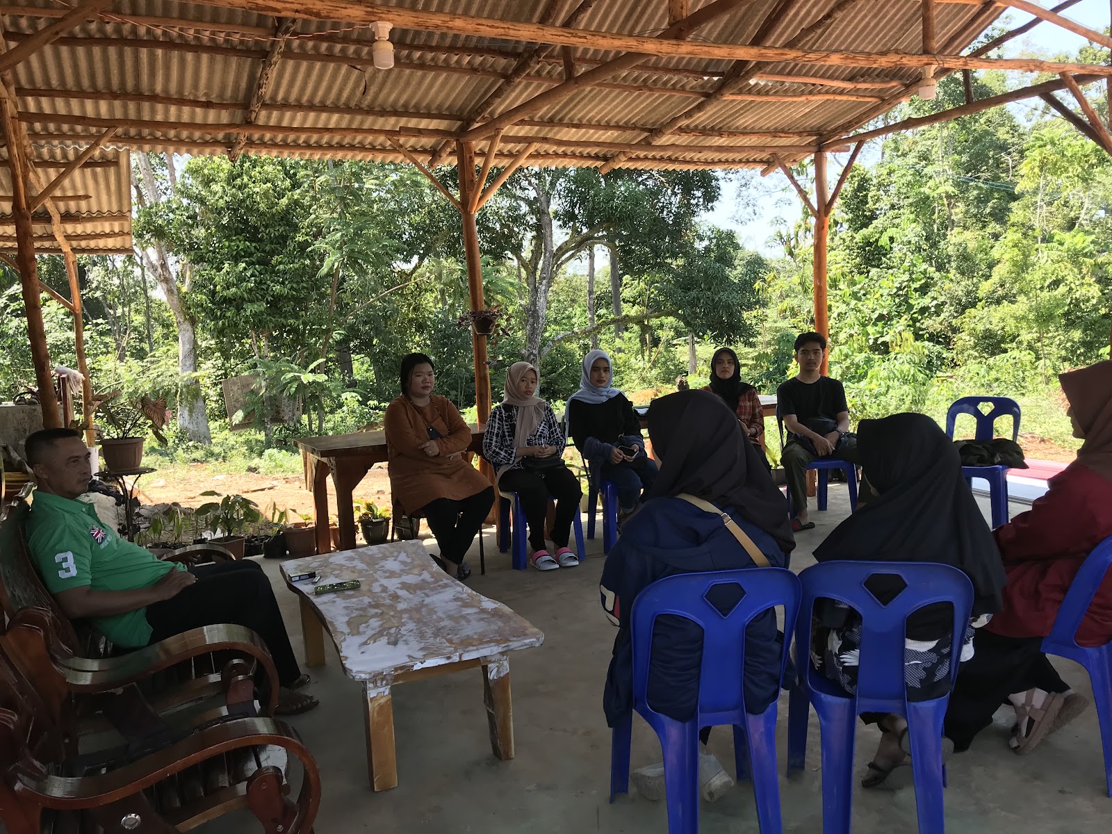 Meeting between teenagers and local villagers under tented shades during a sunny day. Dompak island, blue carbon education, Indonesia coastal communities. CarbonEthics Indonesia
