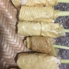 Cắt tàu hủ ky thành những miếng hình chữ nhật. Không nhúng nước mà sử dụng vải lau ướt. Thoa đậu hủ ky 1/2 và xếp thịt 1/2 miếng tàu hủ ki và gắp đôi xếp cuộn chặt lại. Nhớ kẹp sả ở giữa làm chân gà. Sau đó dùng lá chuối và dây lạt buộc chặt lại.