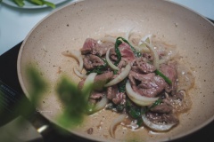 Phi thơm tỏi, đảo sơ hành tây và hành lá, cho phần thịt đã ướp xào đều tay. Thịt bò chín, cho cải thảo vào xào sơ.