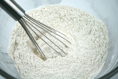 Trộn đều 210g bột mì, 1/2 muỗng muối, 1/2 muỗng bột nở, 1/2 muỗng muối nở vào một âu khác và đặt sang một bên. Cho 115h bơ, 150g đường trắng vào âu và dùng máy đánh trứng đánh bông lên đến khi đường tan hết và hỗn hợp chuyển sang màu sáng hơn là được. Không nên đánh quá lâu sẽ khiến bơ bị tách nước.